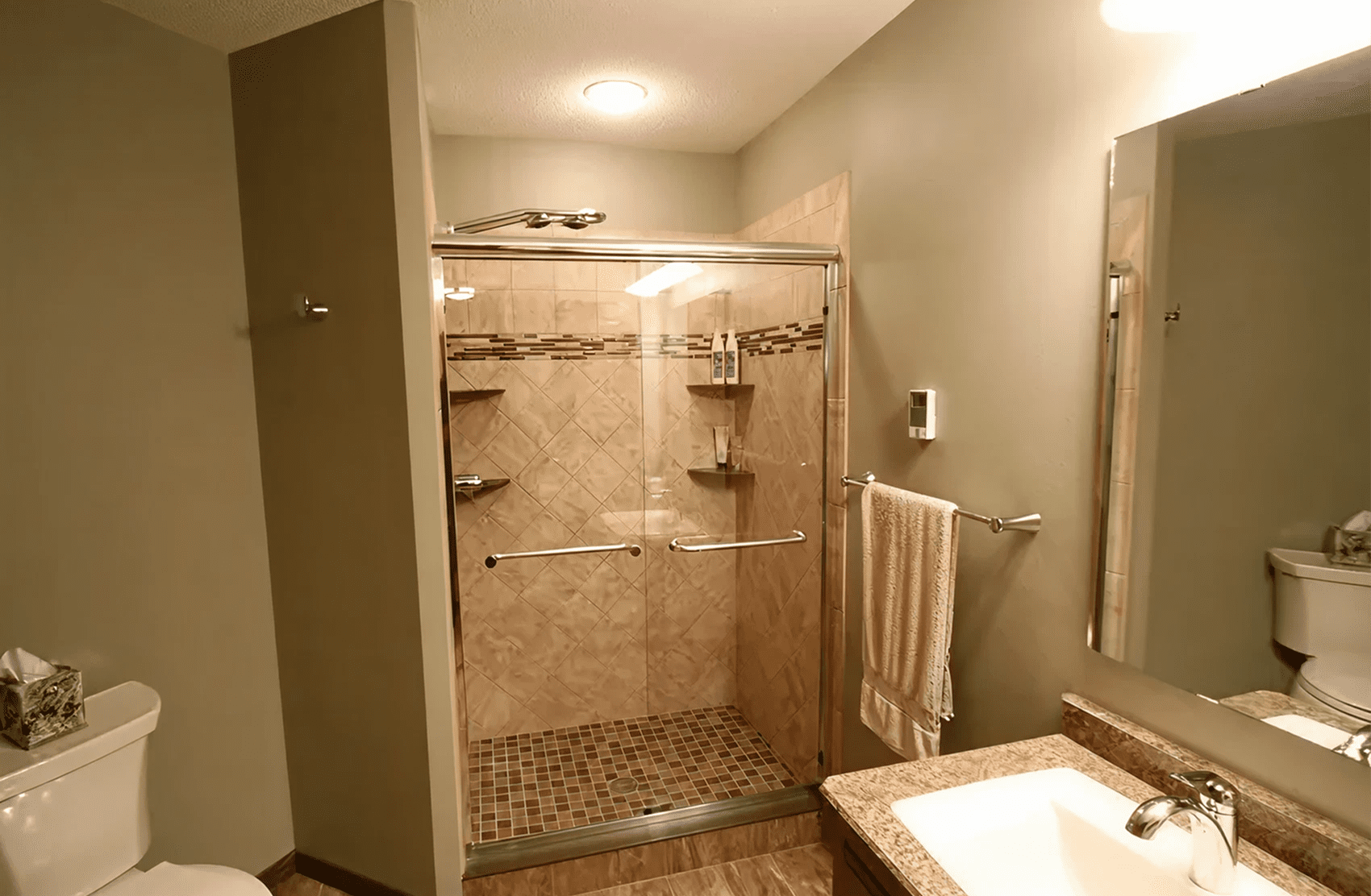 Bathroom featuring glass shower and beige tiles