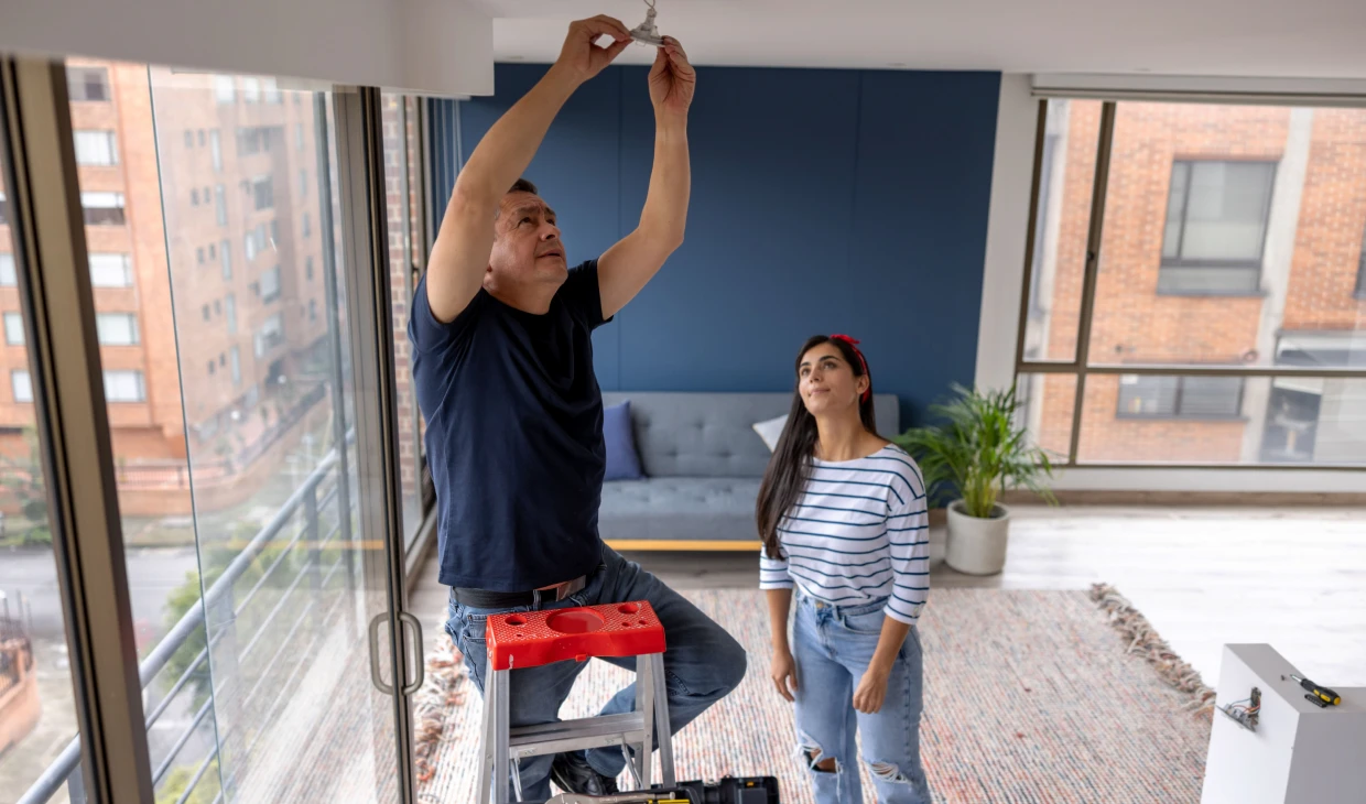 Couple installing light fixture together
