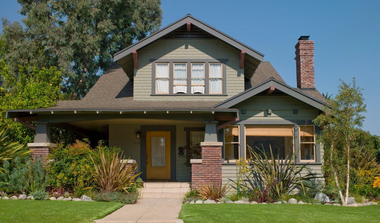 Green and brick home with porch